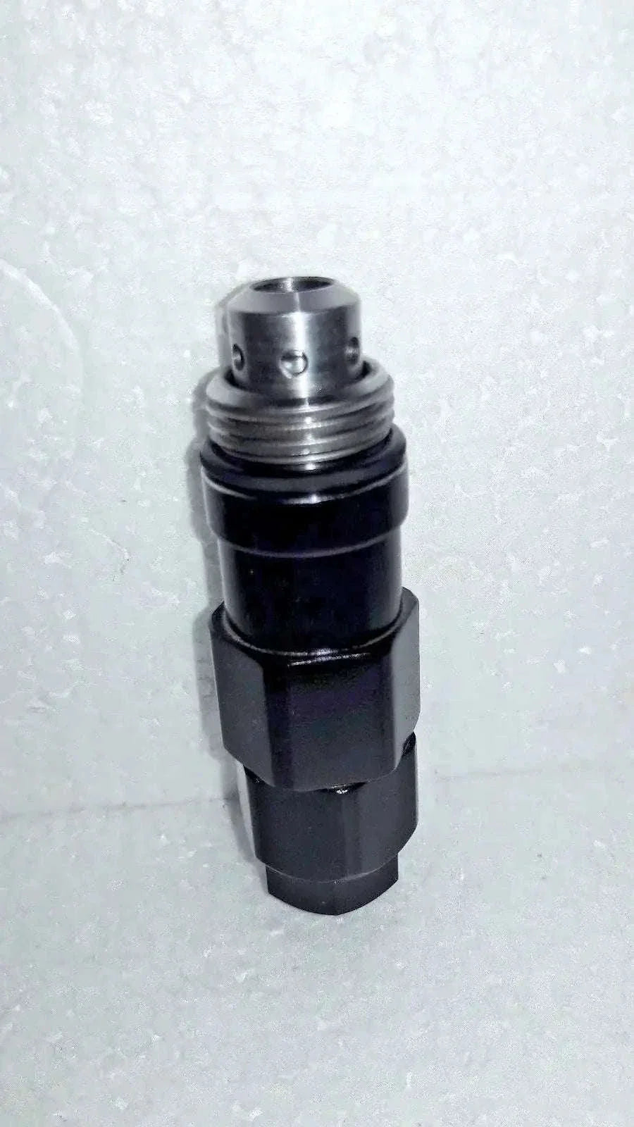 Hydraulic relief valve with silver metal top and black cylindrical body